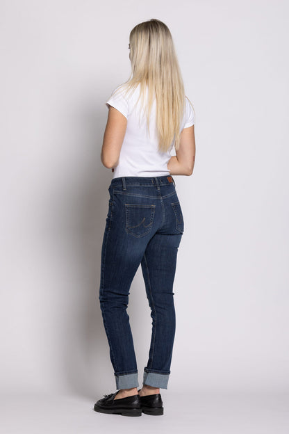 Women wearing blue jeans and a white t-shirt on a plain background