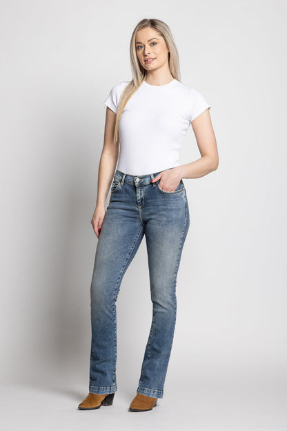 Woman wearing a white t-shirt and blue jeans on a plain background