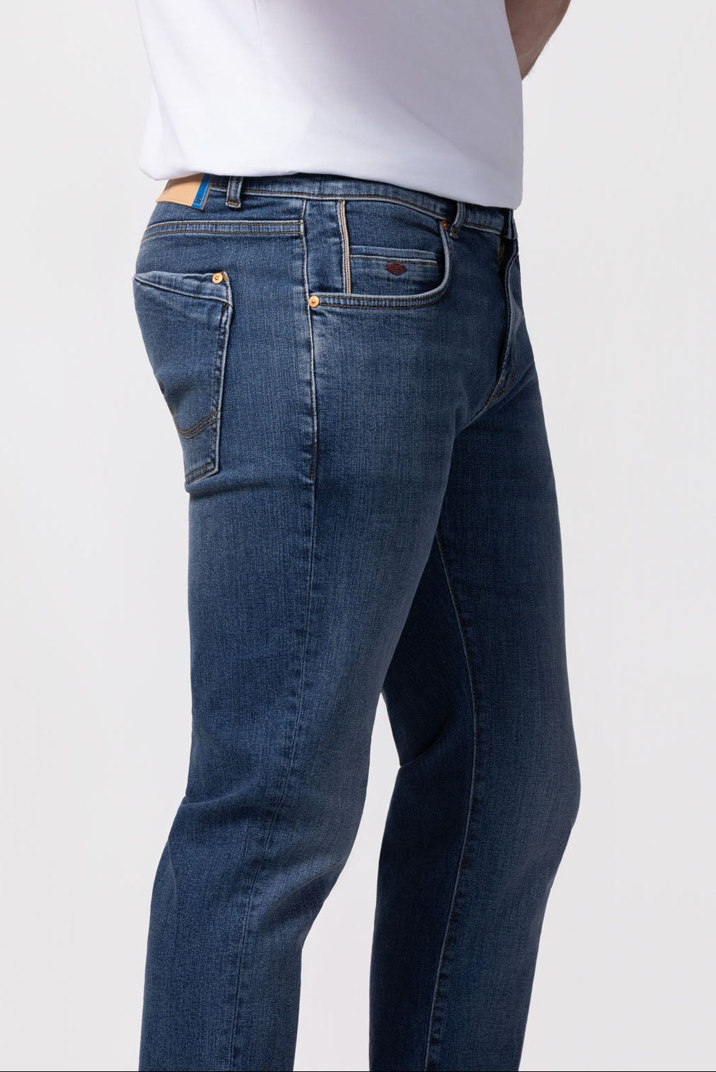 Person wearing blue jeans and a white t-shirt on a white background