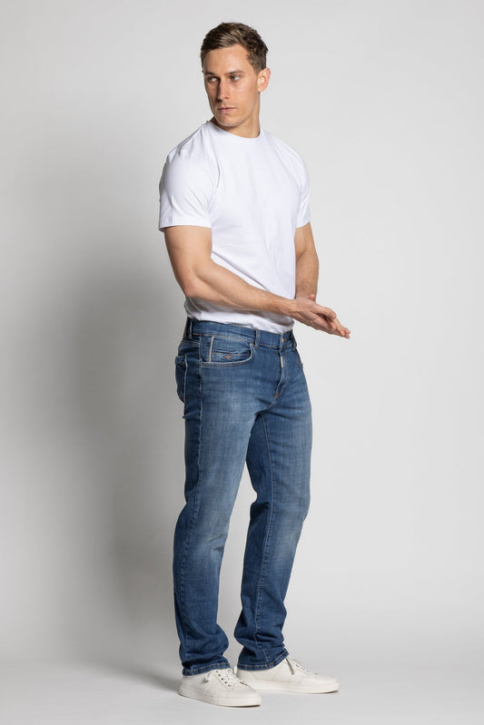 Man wearing a white t-shirt and blue jeans on a plain background