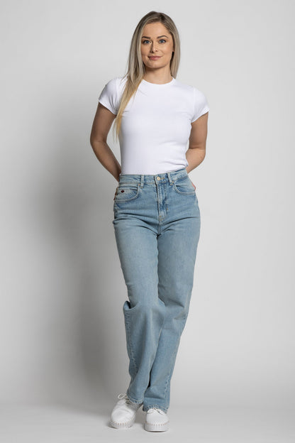 Woman wearing a white t-shirt and light blue jeans on a plain background